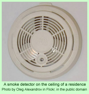 A smoke detector on the ceiling of a residence
