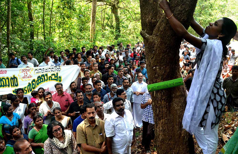 Ms. Geetha before a crowd showing friendship for a forest tree, March 13, 2016