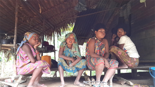 Four Batek people relax in their village 
