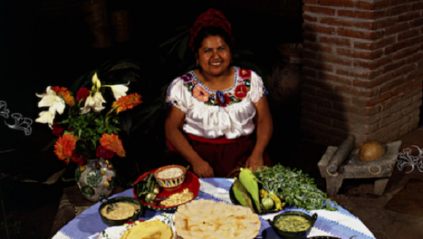Mendoza preparing a meal, taken from the cover of the book DISHDAA'W: la Palabra se Entreteje en la Comida Infinita: la Vida de Abigail Mendoza Ruiz, by Concepción Núñez Miranda