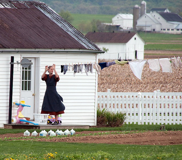 An Amish woman hanging out her laundry 