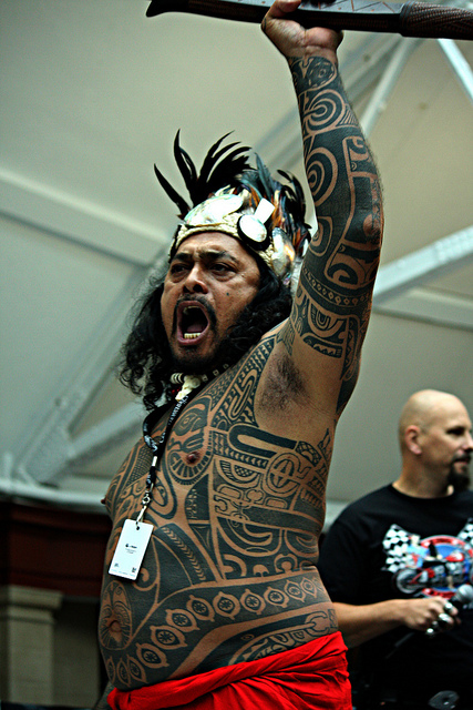 A tattoo artist from Tahiti performing a traditional war dance 
