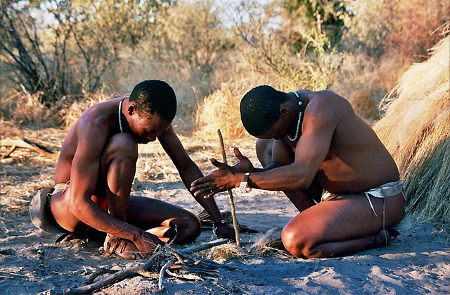 Two San men in Botswana demonstrate how to start a fire by hand (