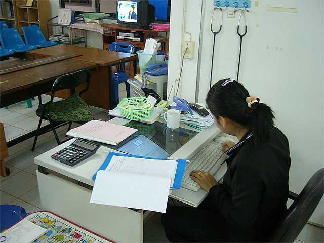 A woman working at a computer in the Na Wa Public Hospital, Nakhon Phanom province of Isaan 