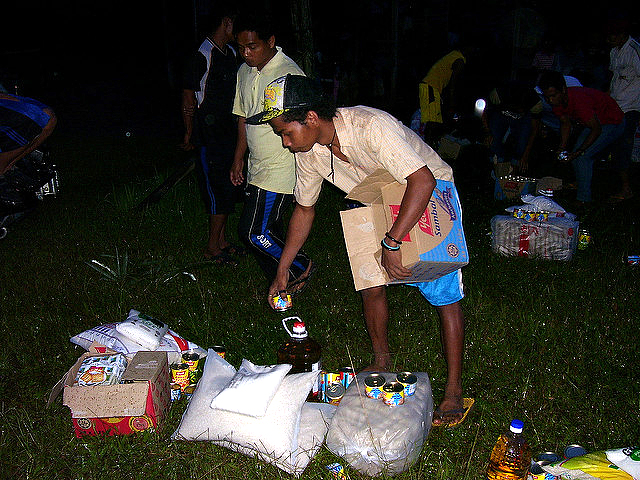 Two Orang Asli youths dividing donated foods into equal parts for twenty two families in Kampong Asli Rening 