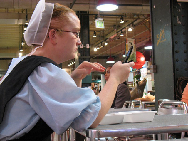 An Amish woman using her cell phone at the Reading Terminal Market in Philadelphia
