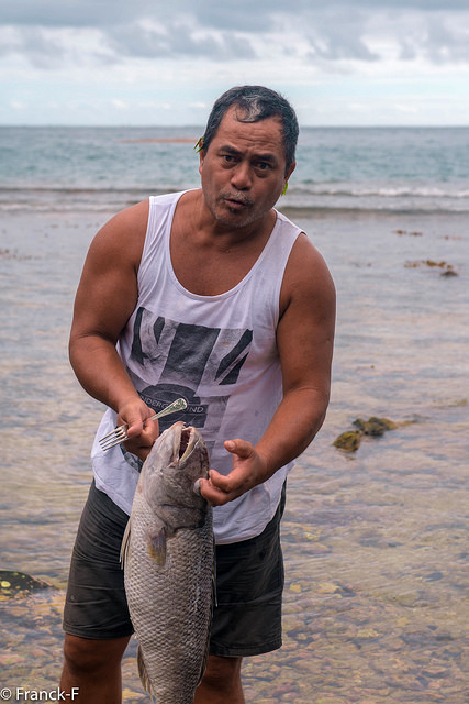 A Tahitian fisherman with a fish he has caught 