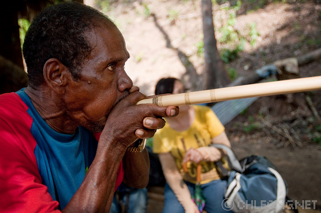 A Batek man shows tourists how he uses his blowpipe in a village along the Tembeling