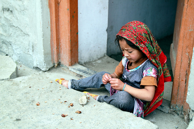 A Turtuk girl playing with apricot seeds