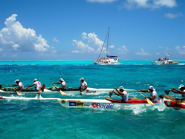 The Hawaiki Nui Va'a canoe race in the Society Islands, yachts filled with tourists in the background