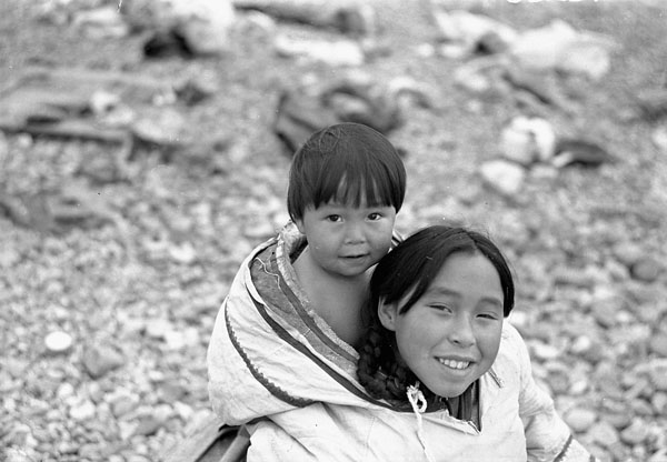 An Inuit girl, Leah, carrying her younger brother, Noah, in her amauti