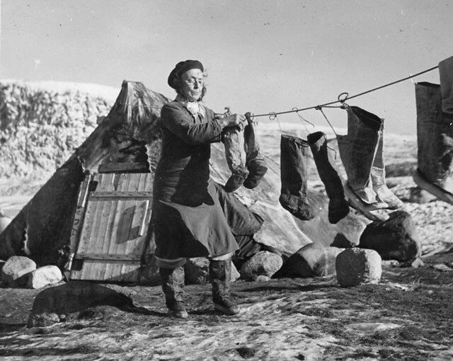 An Inuit woman hangs kamiits, sealskin boots, to dry in Pangnirtung, Nunavut 