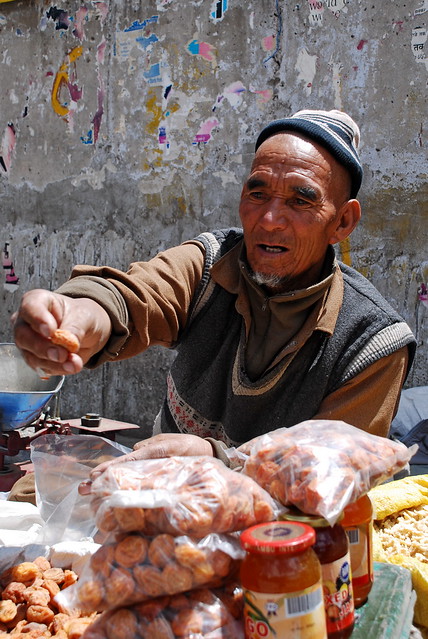 A Ladakhi man sells apricots at a market in Leh (Photo by Irumge in Flickr, Creative Commons license)